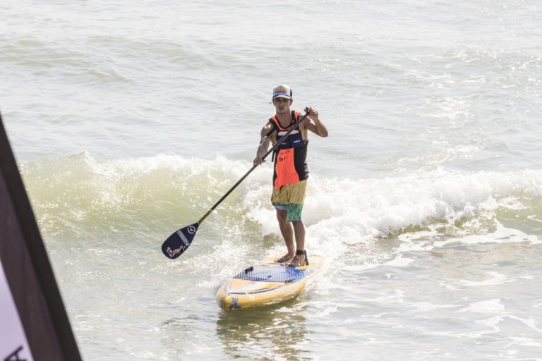 Paddler surfing in to the beach on the Hobie Apex SUP