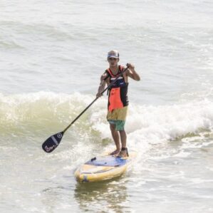 Paddler surfing in to the beach on the Hobie Apex SUP