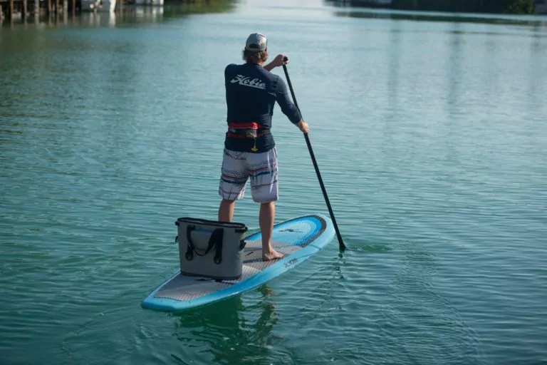 Men with cooler onn the blue Hobie Evalution paddleboard exploring