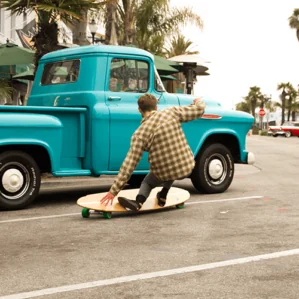 A guy carving the Hamboards Pinger with a classic truck image