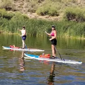 To ladies paddleboarding on Canyon lake in Arizona with Riverbound Sports.