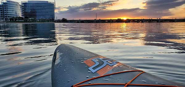 Paddle board on Tempe Town Lake at sunset with a beautiful colored skyline.