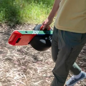 A guy carrying his OneWheel XR using the OneWheel Mahandle.