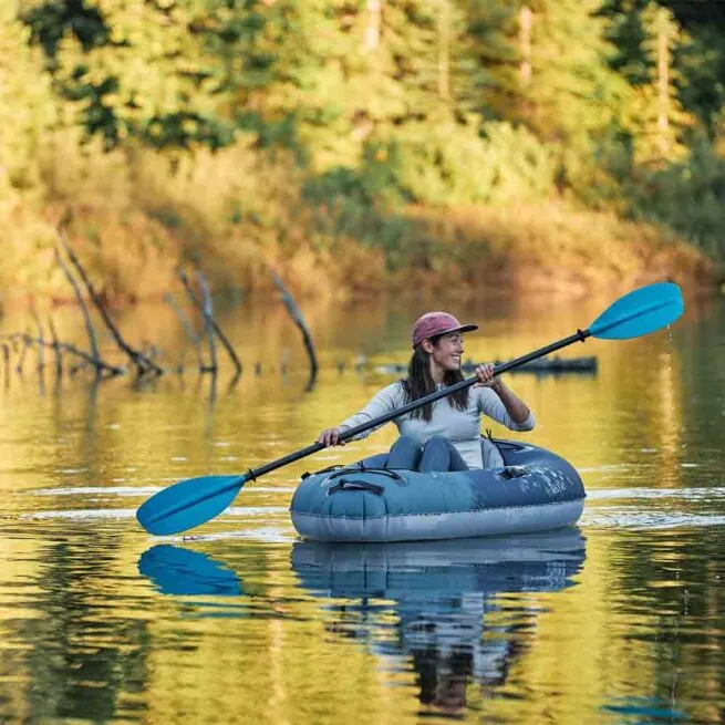A person paddling the new Aquaglide Backwoods Purist Ultralight Kayak on a Fall day.
