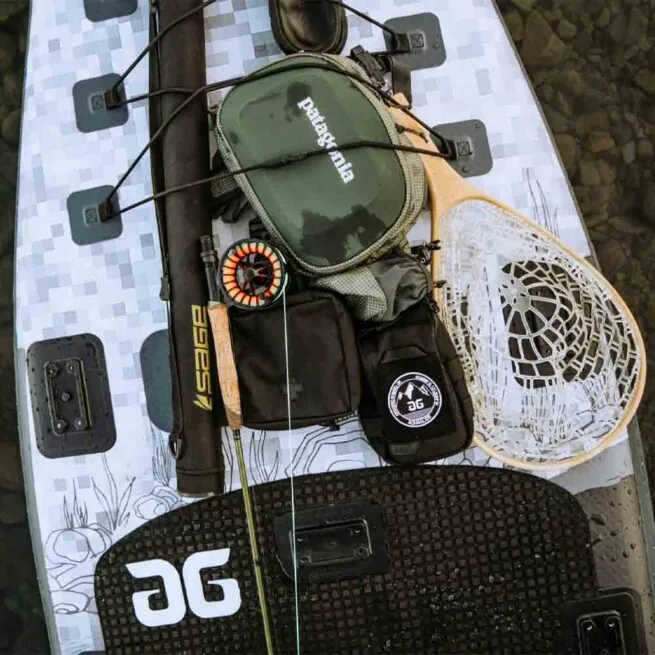 The Aquaglide Blackfoot Angler iSUP deck loaded with fly fishing gear.