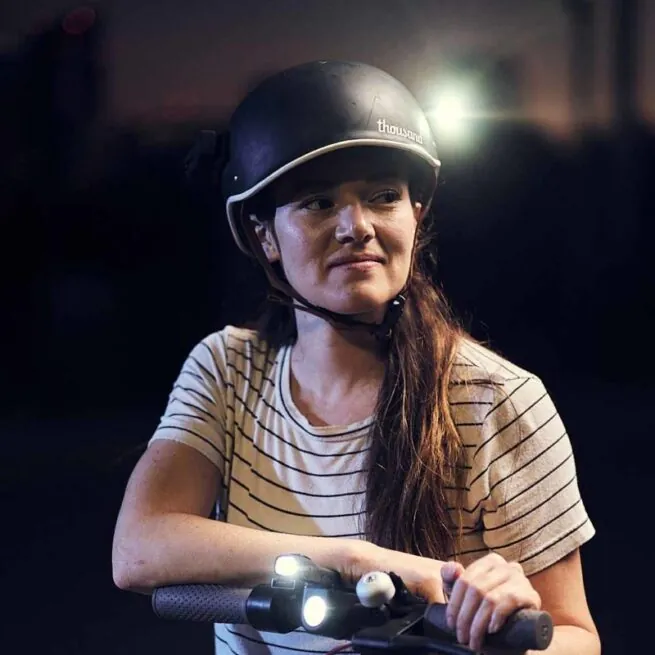 A girl with the ShredLights white light helmet mount on her helmet.
