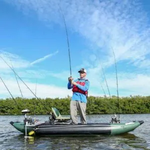 Fisherman standing the Sea Eagle 350FX kayak reeling in a fish.