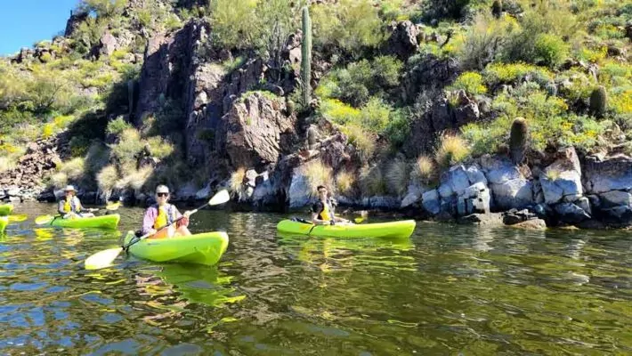 Paddling Saguaro Lake with the beautiful desert landscape in the background. Riverbound Sports kayaking Tours.