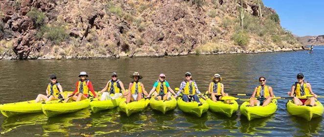 Group kayaking on a sunny day in a lake.