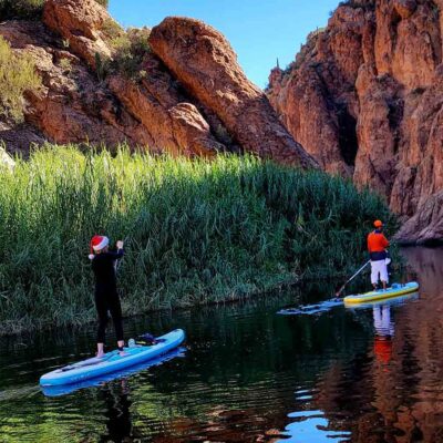 Paddleboarders on Canyon Lake, Arizona paddling through rocky cliffs. Riverbound Sports Paddle Company
