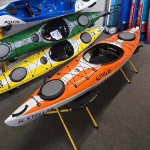 Colorful kayaks displayed in a sports store.