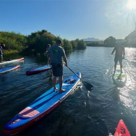 People paddleboarding on the Lower Salt River at sunrise.