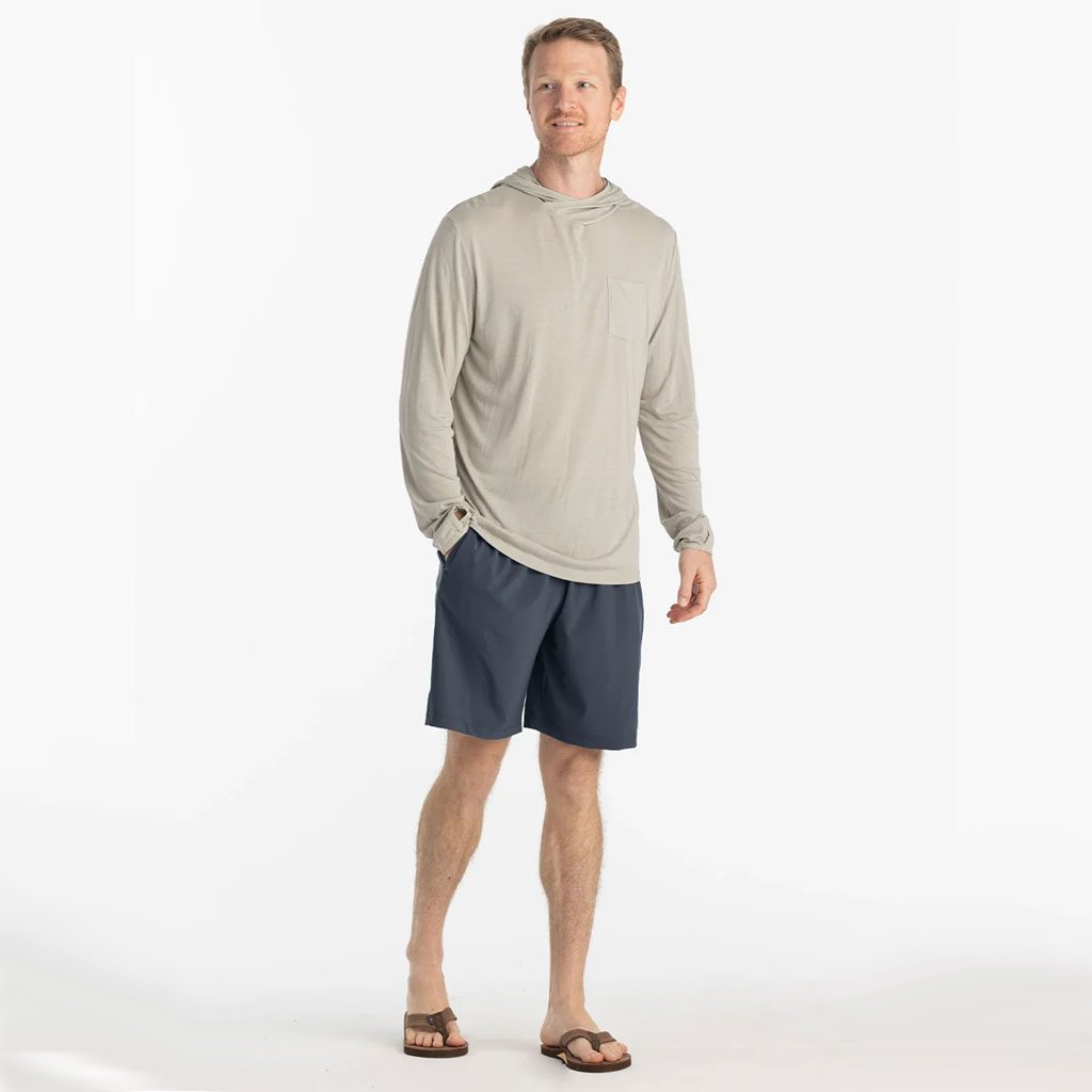 Man in beige hoodie and blue dusk II Free Fly Breeze 8" shorts at Riverbound Sports in Tempe, Arizona.